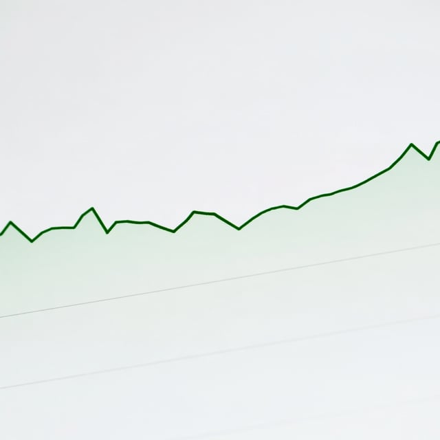 A rising green line chart on a white screen